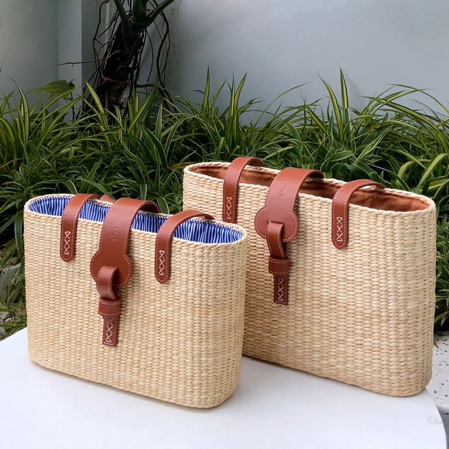 Interior of the large basket bag holding a laptop and sunglasses