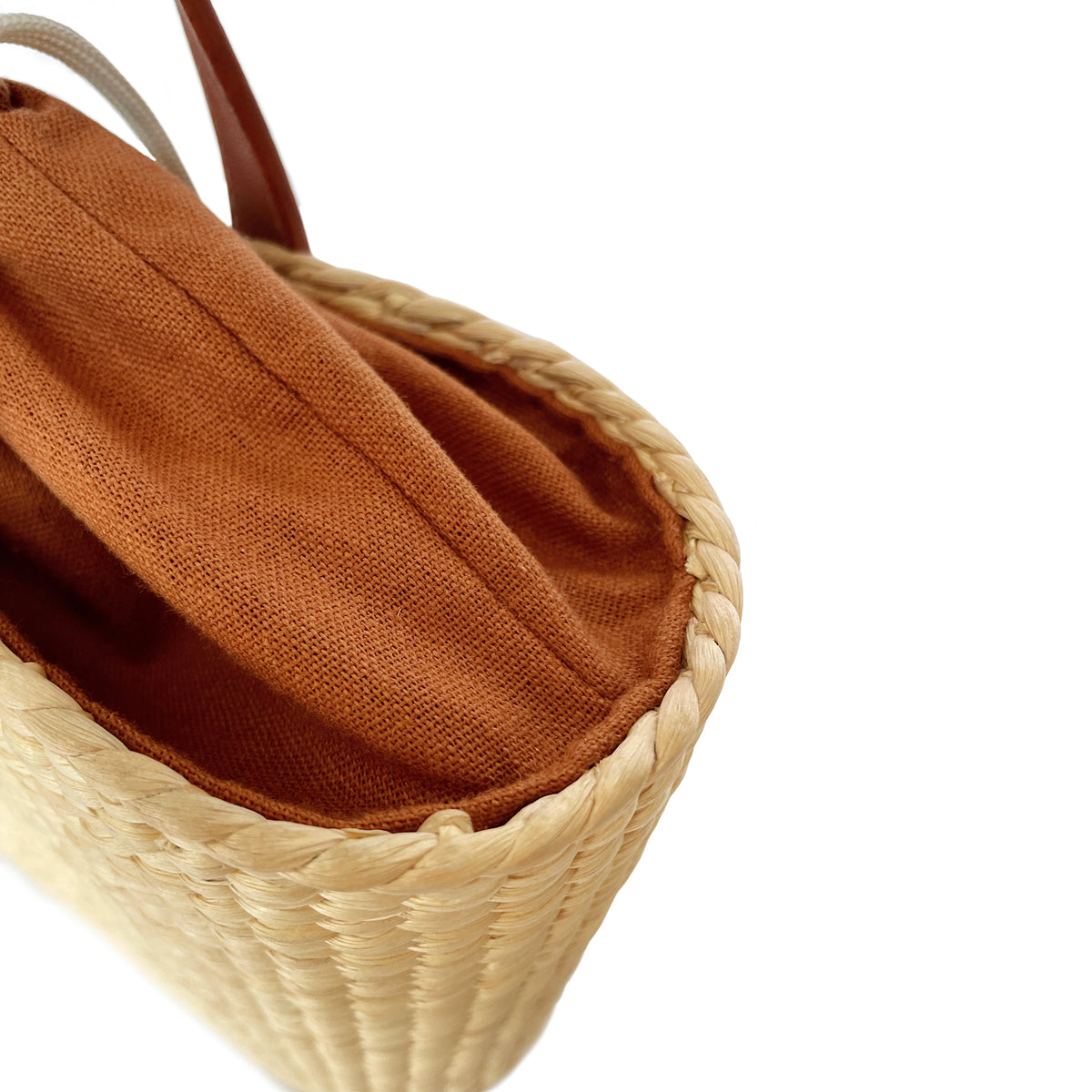 Interior of the basket bag showing terracotta linen lining and drawstring closure
